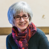 White woman with glasses and white hair