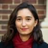 Headshot of Yasemin Akcaguner, showing face and shoulders against a backdrop of red brick. 